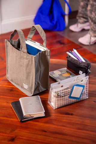 Beige canvas tool tote with two handles, open top and exterior patch logo