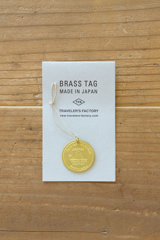 Brass tag bookmark on paper card, engraved “TRAVELER’S FACTORY,” made in Japan