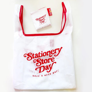 White reusable foldable tote bag with red Stationery Store Day lettering and handles.