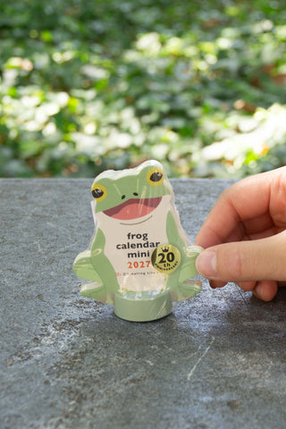 Frog mini die-cut calendar held by fingers, yellow-green with date badge