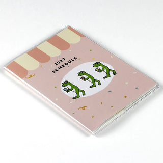 A6 monthly planner closed cover with 2027 schedule and stacked frog illustrations