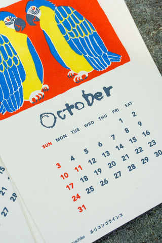 October 2027 stand calendar page close-up with blue and yellow bird illustration and dates