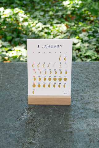 Desk calendar stand with January page and moon phase icons