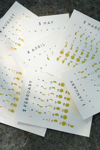 Lunar calendar pages spread out, showing multiple months with moon icons