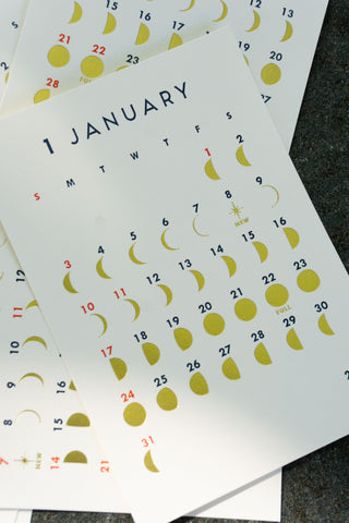 Lunar calendar pages fanned, showing January with moon and date markers