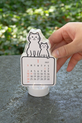 Noritake 2027 cat stand calendar held by hand, front date grid with red highlights