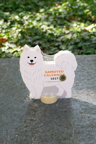 Die-cut Samoyed calendar stand, white dog shape with 2027 date and circular seal
