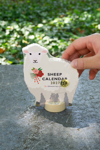 Sheep die-cut desk calendar held in hand, 'SHEEP CALENDAR 2027' on front