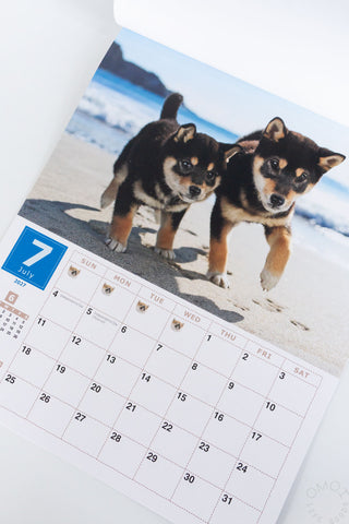 Shiba Inu wall calendar page showing two Shiba Inu dogs on a beach