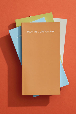 3-month goal planner with multiple pastel cover folders stacked together