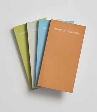 3-month goal planner set with colored covers: olive, green, blue, and orange