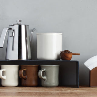 Diner-style ceramic coffee mugs in white, brown, gray, and cream with curved handles