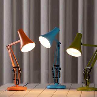 Sunburnt orange mini desk lamp with lit shade and jointed articulated arm