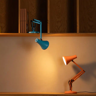 Sunburnt orange mini desk lamp with angled shade on a wooden surface