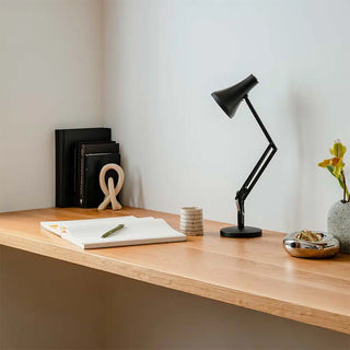 Carbon black mini desk lamp with conical shade and articulated arm on a tabletop