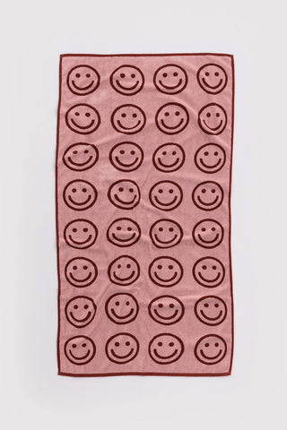 Blush pink bath towel with brown smiley face pattern, rectangular design