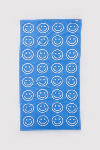 Sky blue bath towel with white smiley face outlines in a repeating pattern