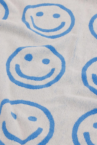 White bath towel with large blue smiley face outlines, close-up