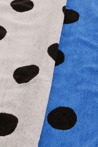 Polka dot hand towel close-up: black dots on light and blue fabric with soft terry texture.