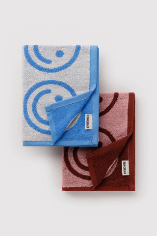 Set of 2 hand towels folded, sky blue and blush pink with smiley face icons