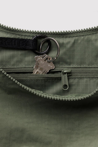 Olive green nylon crescent bag close-up, zipper and D-ring key clip