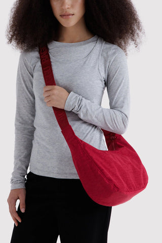 BAGGU medium nylon crescent bag worn crossbody in cherry red