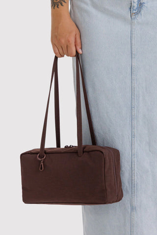 Dark brown nylon bowler bag with long handles and front zipper seam