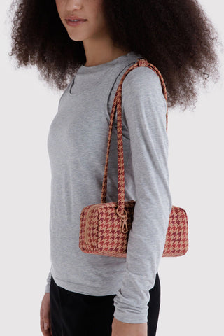 Small houndstooth bowler bag worn over the shoulder, tan handles