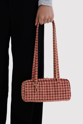 Small houndstooth bowler bag with long tan top handles, front view