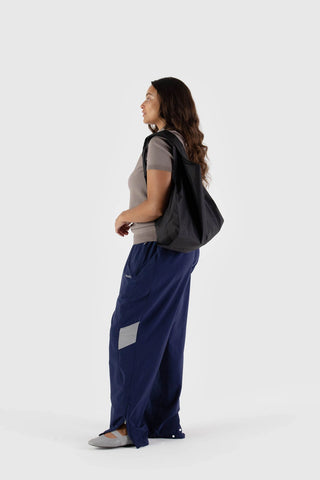 Black tote bag with short handles worn over the shoulder