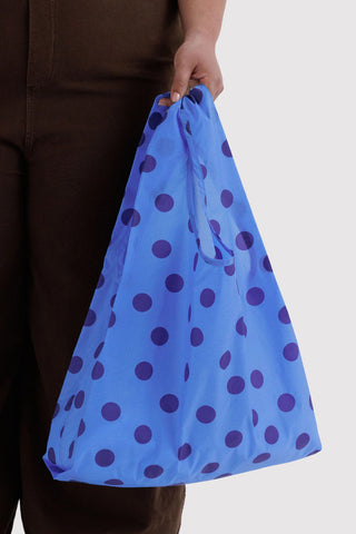 BAGGU tote bag in blue with purple polka dots, held by top straps