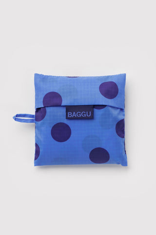 BAGGU tote folded into pouch, blue with purple polka dots and logo tab