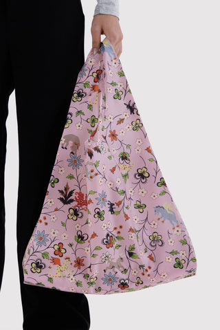 Purple floral standard tote bag with two short handles, carried by hand