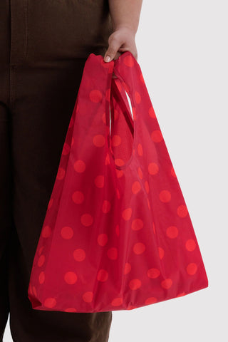 Red polka dot tote bag held in hand with gathered fabric sides