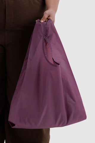 Wild plum reusable tote bag held by the handles, with gathered sides