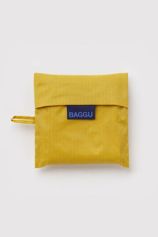 Folded yellow BAGGU tote pouch with blue logo label and small loop handle