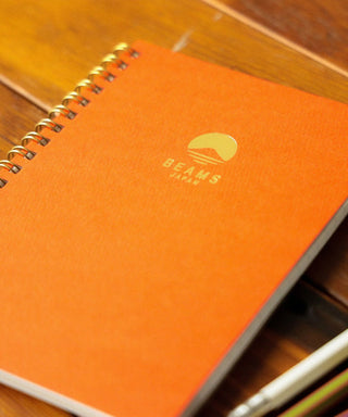 Orange BEAMS Japan lined notebook cover with centered BEAMS logo