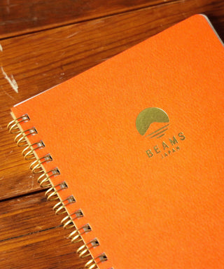 Orange BEAMS Japan lined notebook cover with BEAMS logo and metal spiral binding