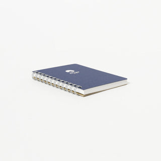 Navy lined notebook with gold spiral binding and BEAMS Japan logo on cover.