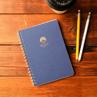 Navy lined notebook with spiral binding and BEAMS Japan logo on cover.