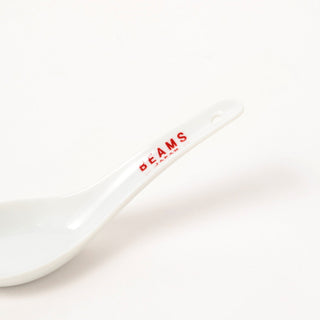 White ceramic soup spoon by BEAMS Japan, close-up of red logo on handle