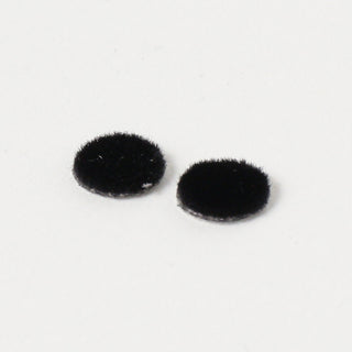 Two small black felt eyelash pieces on a white background
