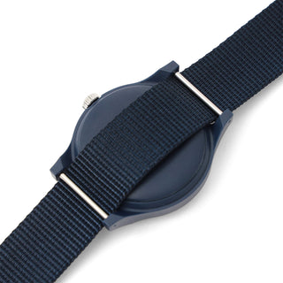 Navy woven watch strap with metal buckle and brushed case edge detail