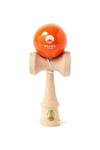 Wooden kendama with orange ball labeled BEAMS JAPAN, tied with white cord