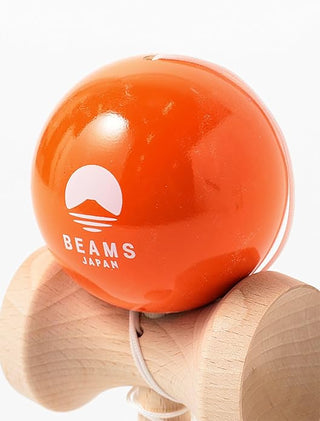 Close-up of orange kendama ball with BEAMS JAPAN logo on natural wooden cup