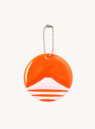 Orange circular reflector keychain with silver bead chain and white graphic stripes