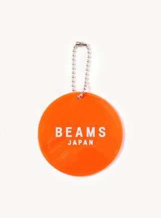 Orange circular reflector with BEAMS JAPAN logo text and silver bead chain on front