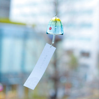 Blue and yellow glass bell wind chime with hanging string and paper tag