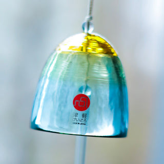 Blue glass wind chime bell with gold top and red logo on hanging paper tag