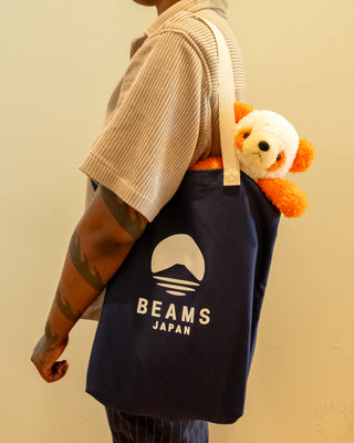Navy BEAMS Japan tote bag with orange-and-white plush panda and BEAMS logo